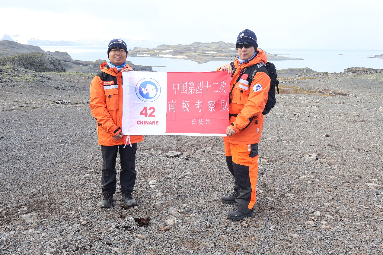 何兆國副教授（右）與隊友在南極野外考察時，手持中國第四十二次南極考察隊隊旗合影